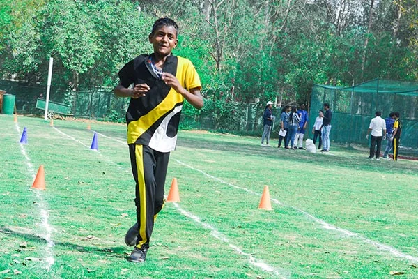 Student running on the athletics track during sports day